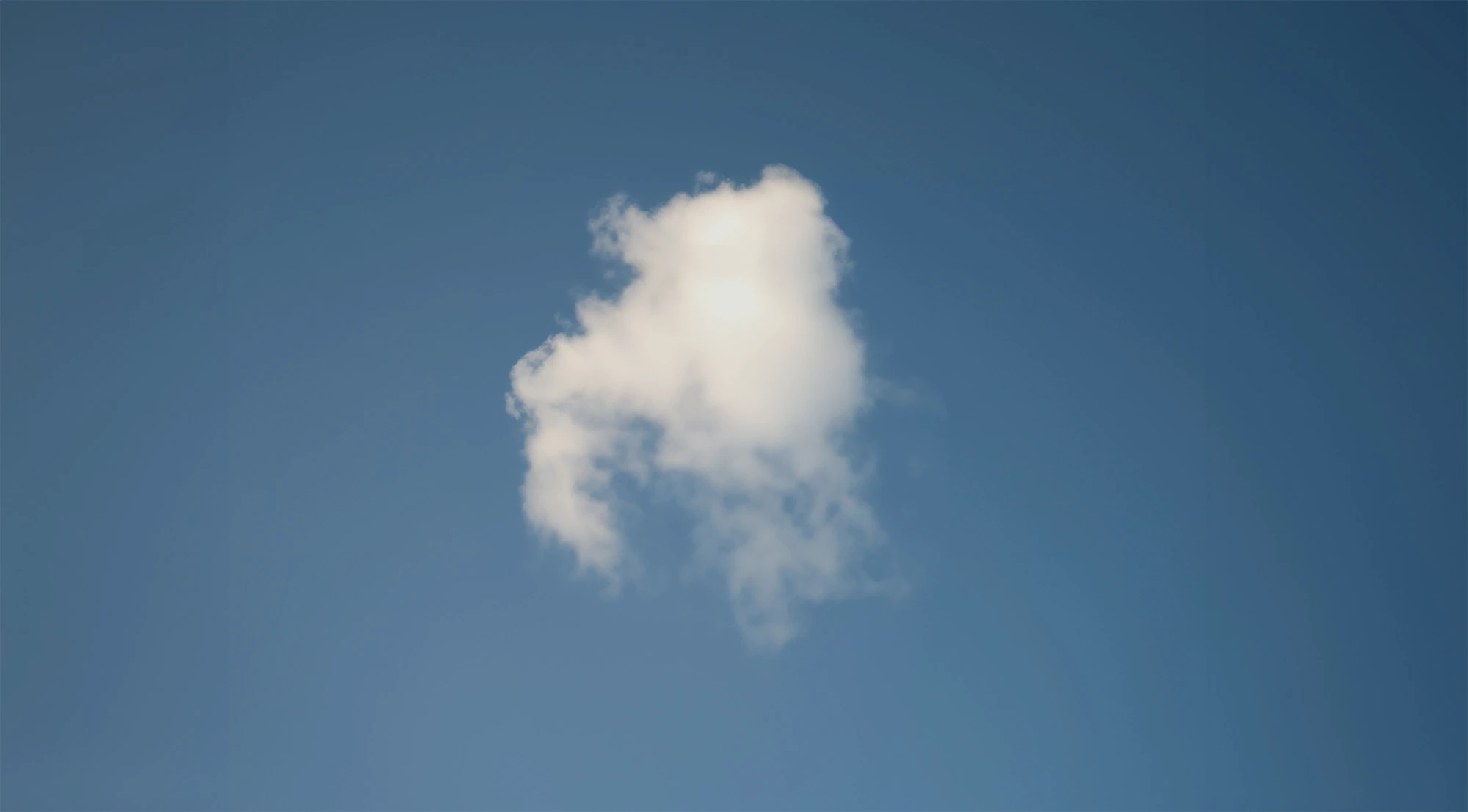 A small, white cloud against a clear blue sky.